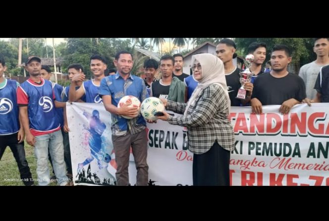 
					Hj Aisyah Ismail S.Ag, menyerahkan Piala Sang Juara Turnamen Sepakbola di Idi Tunong