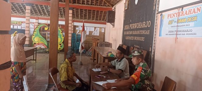 
					Anggota Babinsa Desa Purwoharjo Koramil 23/Karangtengah Serda Suyanto, turut membantu kelancaran kegiatan pendampingan dan monitoring kegiatan pembagian BLT DD