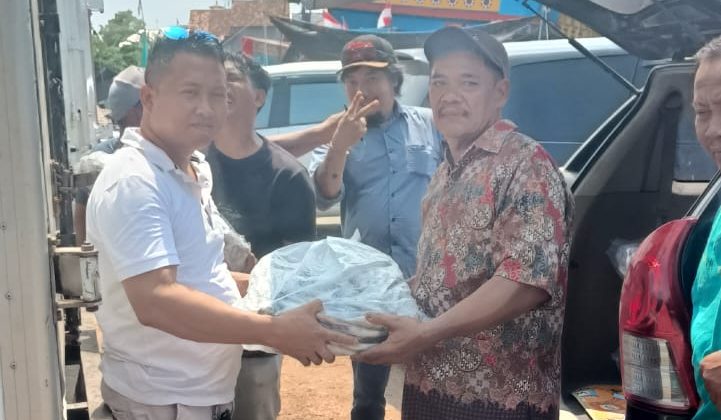 Caleg DPRD Pati Dapil 3 dari Partai Demokrat, Mukit (kiri) membagikan ikan kepada masyarakat yang juga timsesnya sebagai bentuk kepedulian
