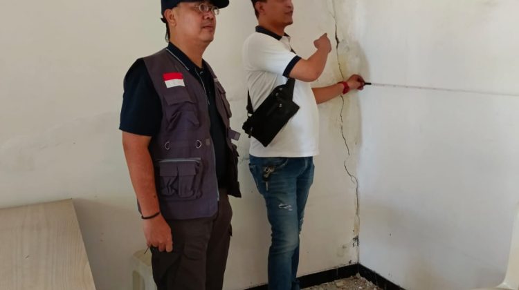 Karman Sastro menunjukkan keretakan bangunan akibat pembangunan ruko yang melanggar Perda