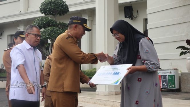 
					Sekda Kota Malang, Erik Setyo Santoso, menyerahkan santunan jaminan kematian kepada empat orang ahli waris peserta BPJS Ketenagakerjaan yang telah meninggal dunia, Senin (2/3/2026). (Foto:Dok.Pemkot Malang)

