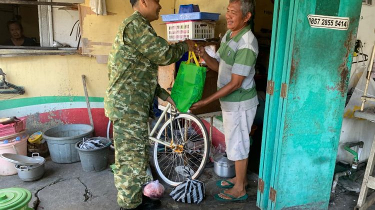 Babinsa Kelurahan Kepatihan Wetan Koramil 04/Jebres Kodim 0735/Surakarta Sertu Budiono membagikan bingkisan sembako kepada warga kurang mampu. (Foto:Arda72)
